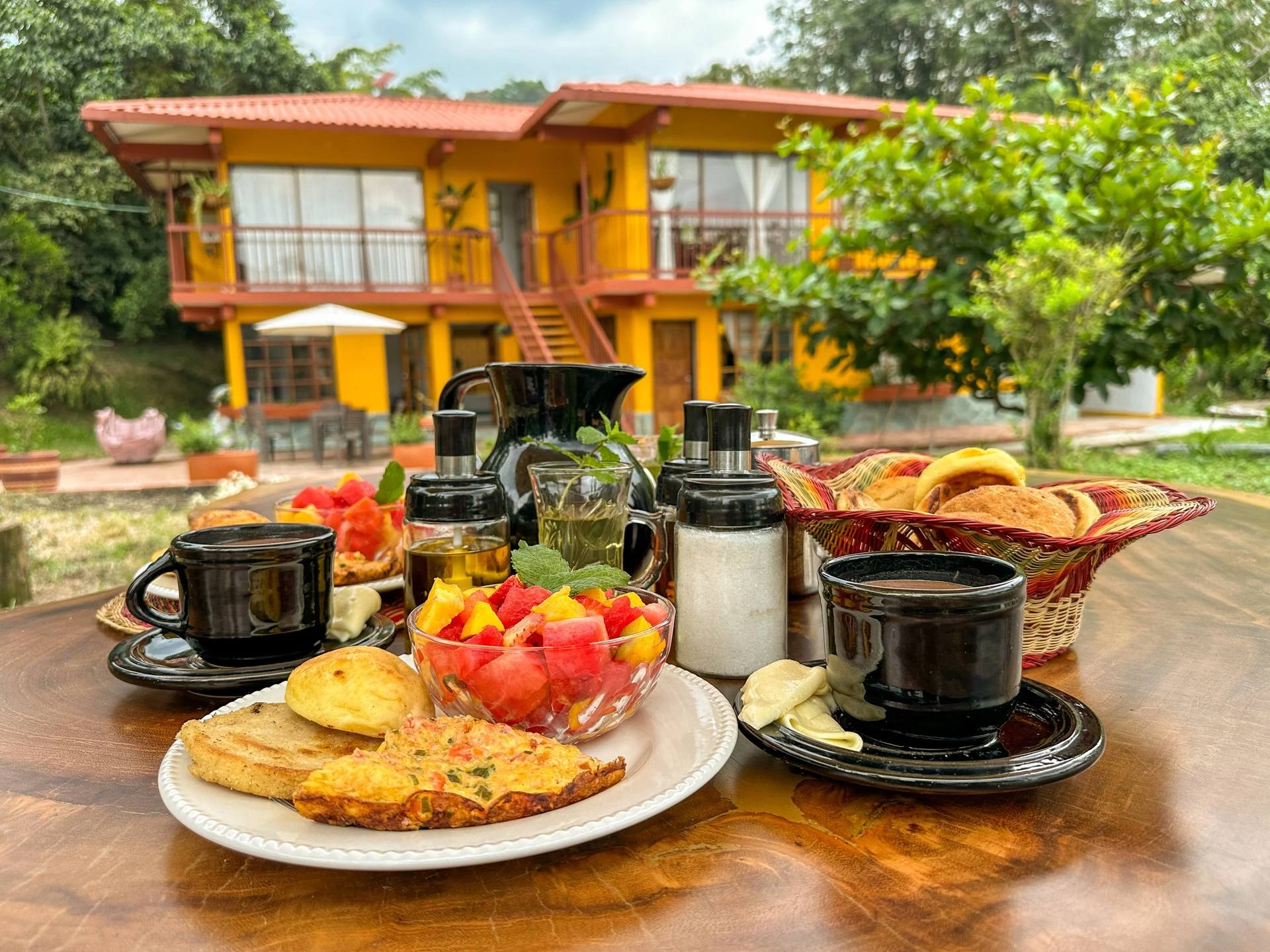 Desayuno con frutas, panes y café en El Nido Andino